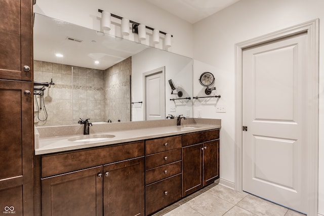 bathroom featuring tiled shower, vanity, and tile patterned floors