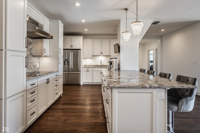 kitchen featuring exhaust hood, dark wood-type flooring, a kitchen bar, and stainless steel fridge with ice dispenser