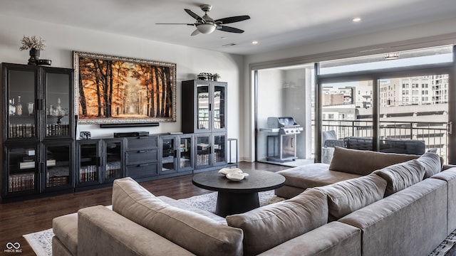 living room featuring ceiling fan and dark wood-type flooring