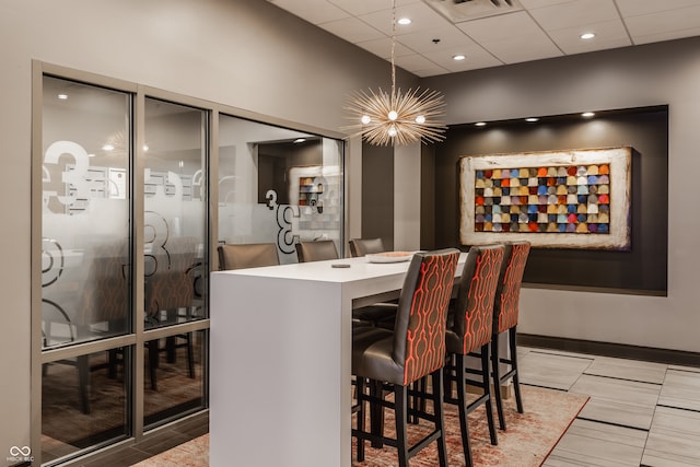 dining area featuring an inviting chandelier and a paneled ceiling