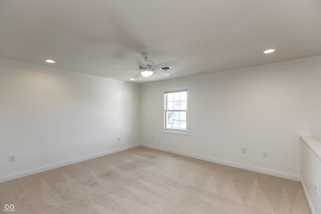 carpeted spare room featuring crown molding and ceiling fan