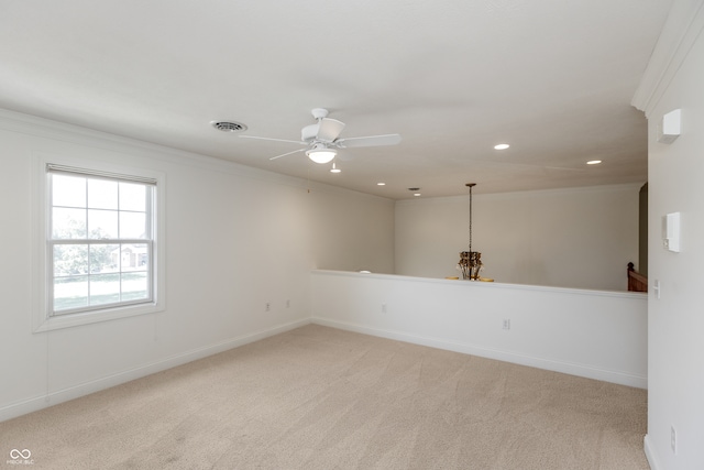 carpeted empty room with crown molding and ceiling fan with notable chandelier