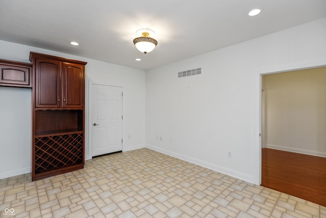 spare room with recessed lighting, baseboards, and visible vents