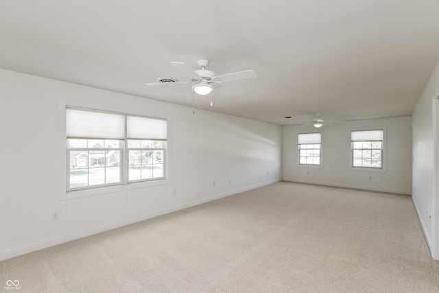 carpeted spare room featuring ceiling fan