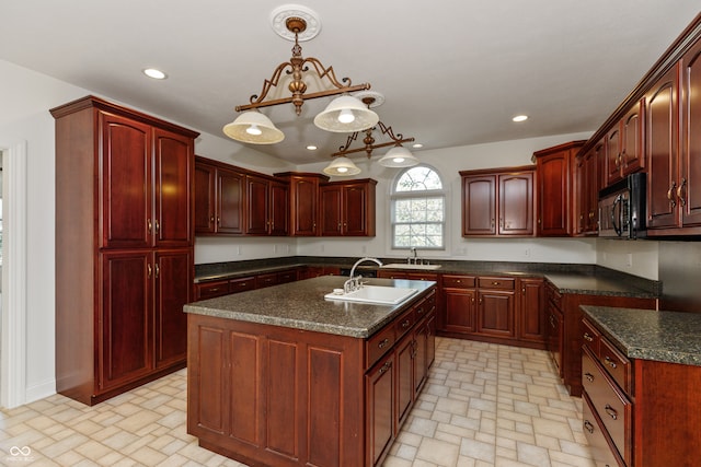 kitchen with sink, a center island with sink, and hanging light fixtures