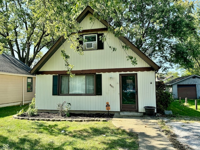 view of front of property with an outdoor structure, a garage, and a front yard