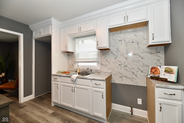 kitchen with decorative backsplash, white cabinetry, dark wood-type flooring, and sink