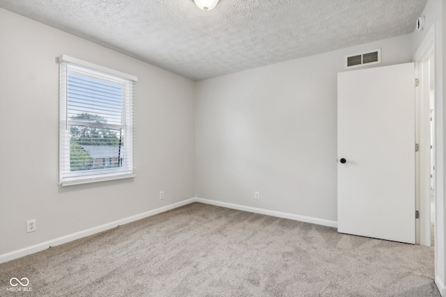 carpeted spare room featuring a textured ceiling