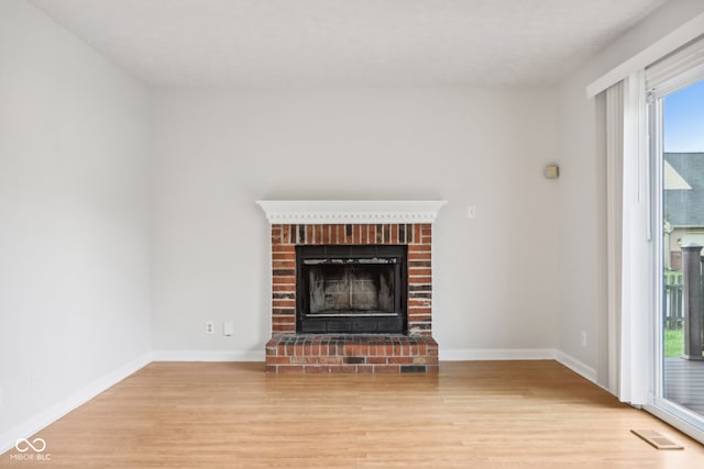 unfurnished living room featuring light wood-type flooring and a fireplace