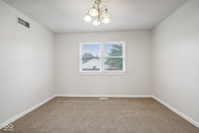 unfurnished room with a textured ceiling, a chandelier, and carpet