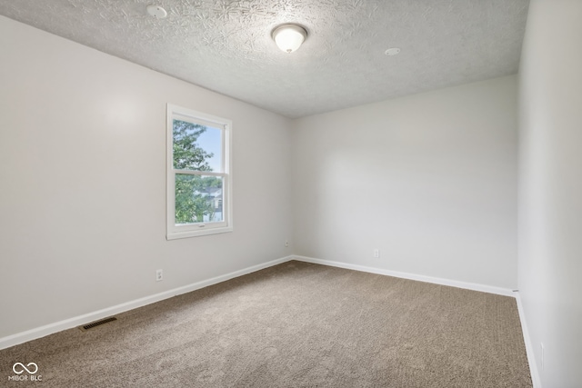 empty room featuring a textured ceiling and carpet floors