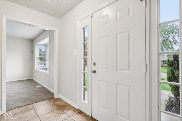 tiled foyer featuring a wealth of natural light and a textured ceiling