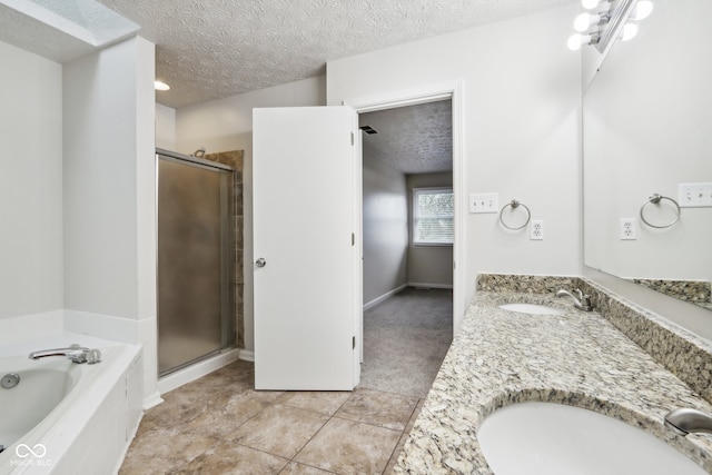 bathroom featuring plus walk in shower, tile patterned flooring, a textured ceiling, and vanity