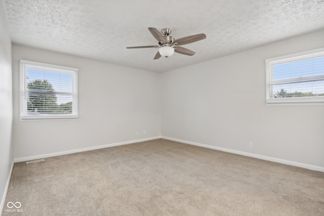 carpeted empty room featuring ceiling fan and a textured ceiling