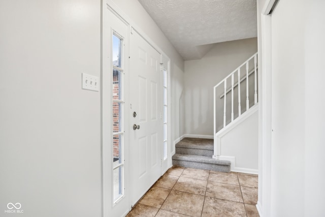 tiled foyer entrance with a textured ceiling