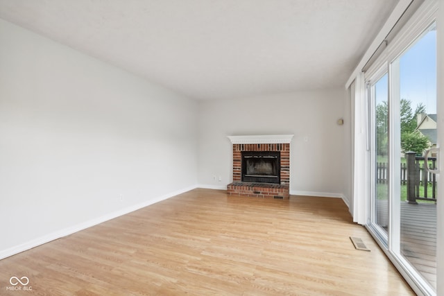 unfurnished living room featuring light wood-type flooring and a fireplace