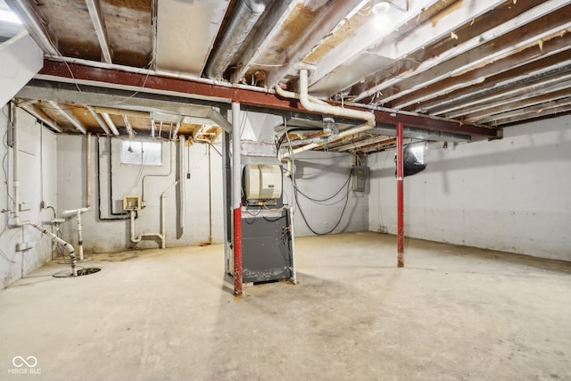 basement with electric panel and heating unit