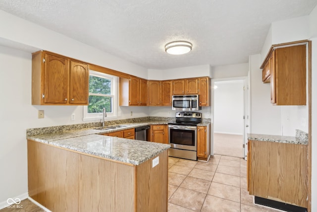 kitchen with stainless steel appliances, kitchen peninsula, a textured ceiling, and sink