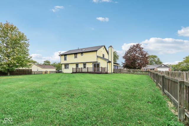 rear view of property with a wooden deck and a yard