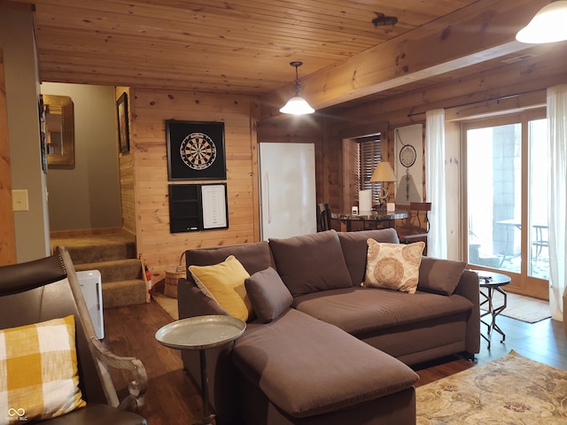 living room with dark wood-type flooring, wooden ceiling, and wooden walls