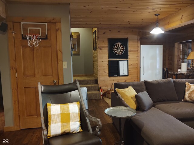 living room featuring dark wood-type flooring, wood ceiling, and wooden walls