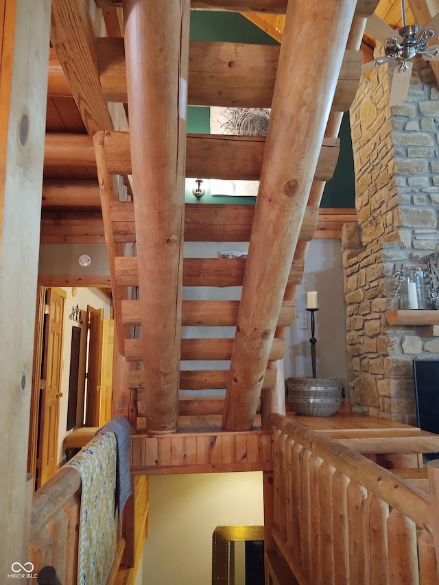 staircase featuring beam ceiling and a fireplace