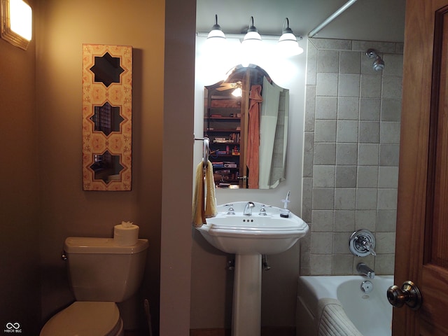 full bathroom with toilet, tiled shower / bath combo, and sink