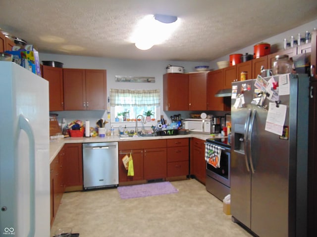 kitchen featuring light carpet, stainless steel appliances, a textured ceiling, and sink