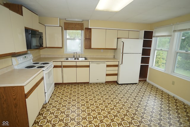 kitchen featuring white appliances, a healthy amount of sunlight, and sink