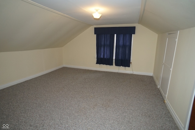 bonus room with lofted ceiling and carpet flooring