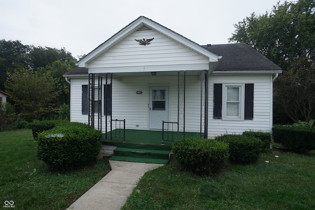 bungalow-style home featuring a front lawn and covered porch