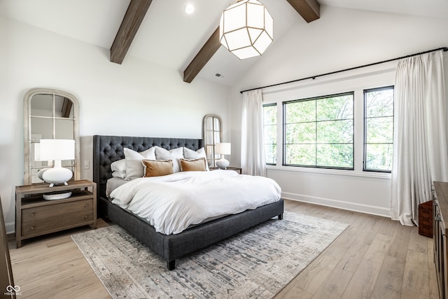 bedroom with light wood-type flooring, beam ceiling, and high vaulted ceiling