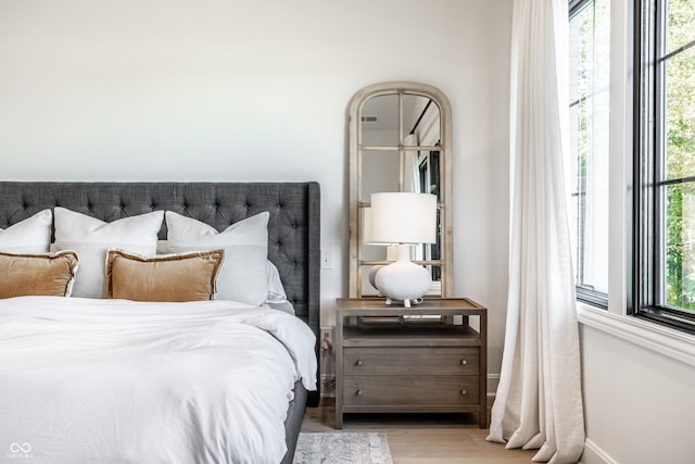 bedroom featuring multiple windows and light wood-type flooring