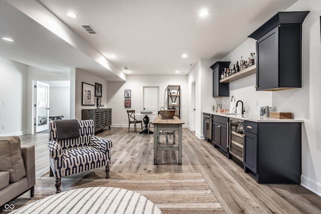 kitchen featuring a center island, light hardwood / wood-style floors, a kitchen bar, and sink