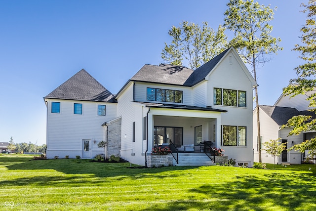 back of house featuring a yard and covered porch