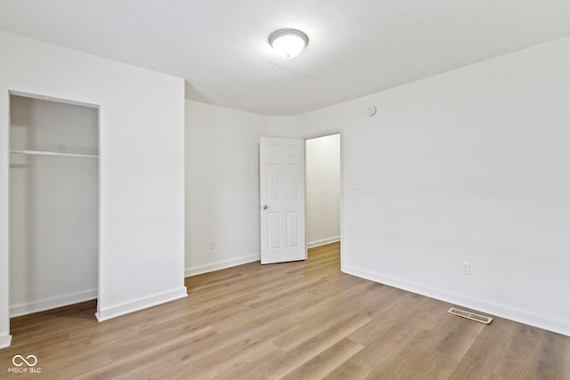 unfurnished bedroom featuring a closet and light hardwood / wood-style flooring