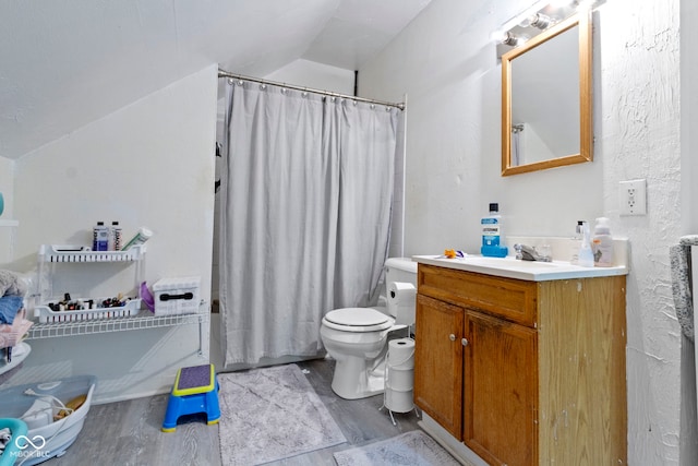 bathroom featuring vanity, wood-type flooring, a shower with curtain, vaulted ceiling, and toilet