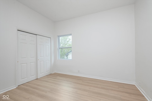 unfurnished bedroom with light hardwood / wood-style flooring and a closet