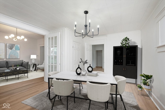 dining space featuring an inviting chandelier, crown molding, and hardwood / wood-style floors