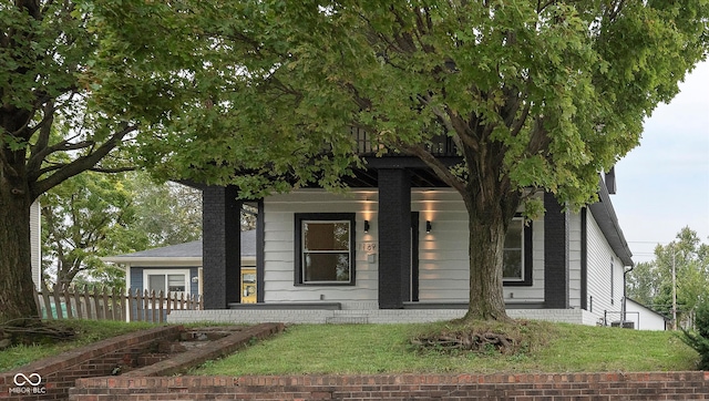 view of property hidden behind natural elements featuring a front lawn