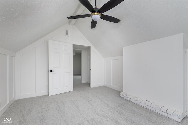 additional living space with ceiling fan, light colored carpet, a textured ceiling, and vaulted ceiling