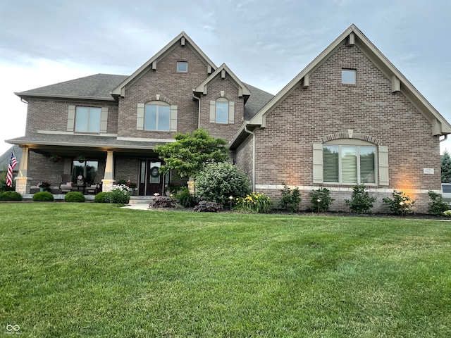 view of front of home with a porch and a front lawn