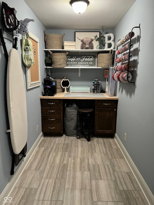 office area with a textured ceiling and light hardwood / wood-style flooring