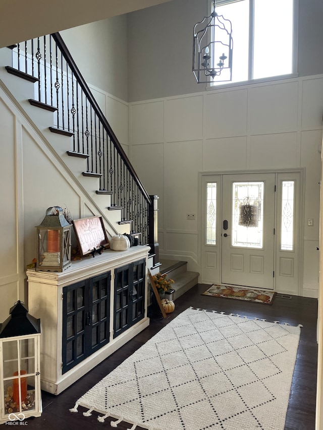 entrance foyer with a towering ceiling and dark hardwood / wood-style flooring