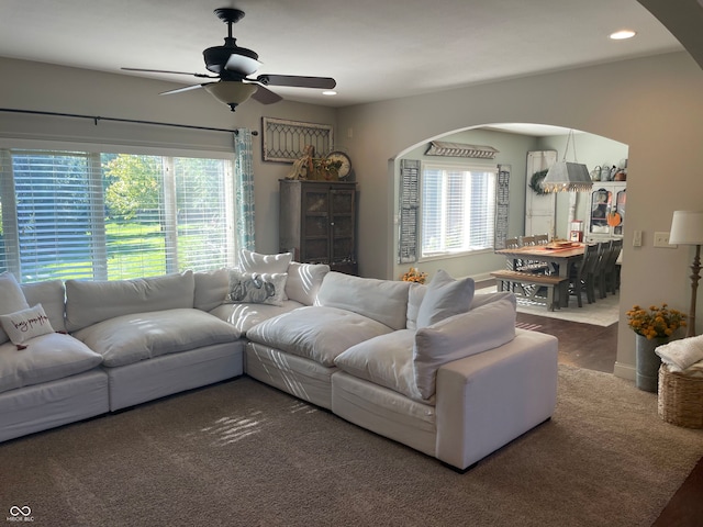 living room with ceiling fan and dark carpet