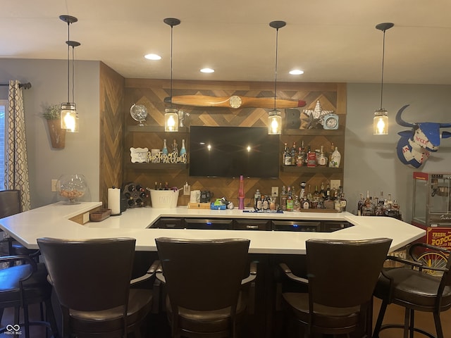 bar featuring pendant lighting, decorative backsplash, and stainless steel dishwasher