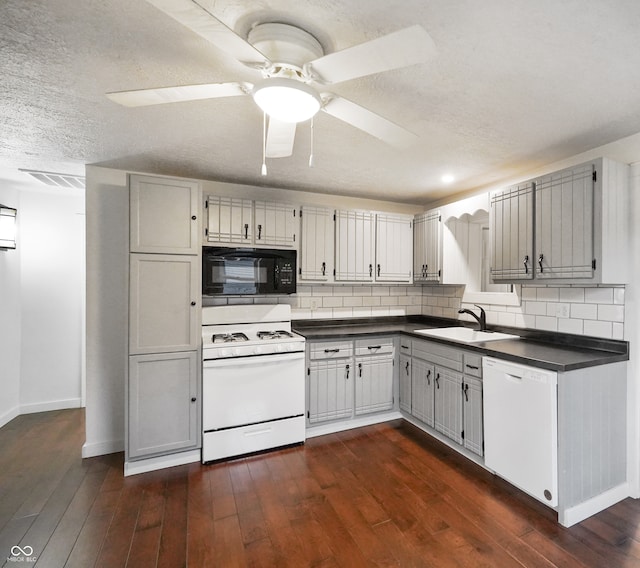 kitchen featuring dark wood-type flooring, sink, white appliances, and tasteful backsplash