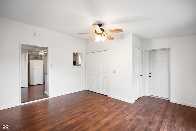 unfurnished bedroom featuring ceiling fan, dark wood-type flooring, and white refrigerator