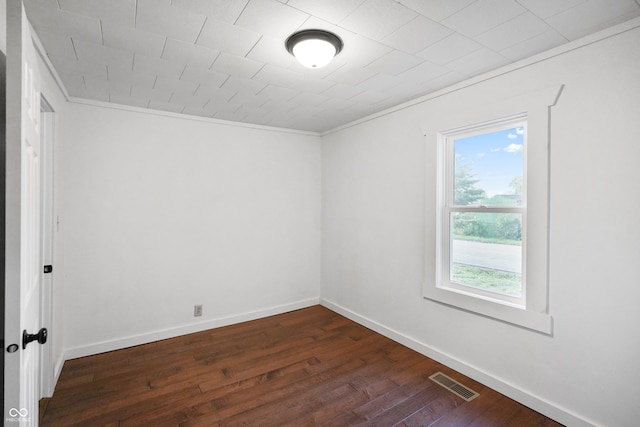 unfurnished room featuring crown molding and dark wood-type flooring