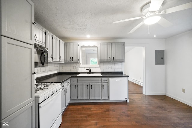 kitchen featuring sink, white appliances, tasteful backsplash, gray cabinets, and dark hardwood / wood-style floors